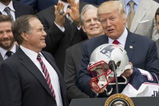 US President Donald Trump holds a football helmet given to him by New England Patriots.