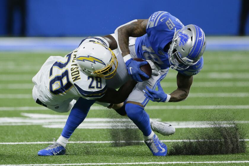 Los Angeles Chargers defensive back Brandon Facyson (28) brings Detroit Lions wide receiver Kenny Golladay (19) down after a reception in the first half of an NFL football game in Detroit, Sunday, Sept. 15, 2019. (AP Photo/Duane Burleson)