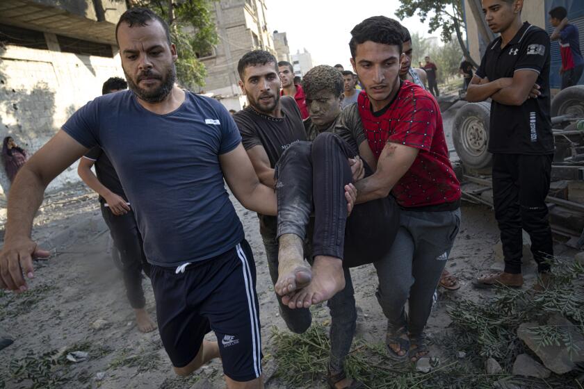 Palestinians carry a person wounded in Israeli airstrikes in Khan Younis, Gaza Strip, Monday, Oct. 16, 2023. (AP Photo/Fatima Shbair)