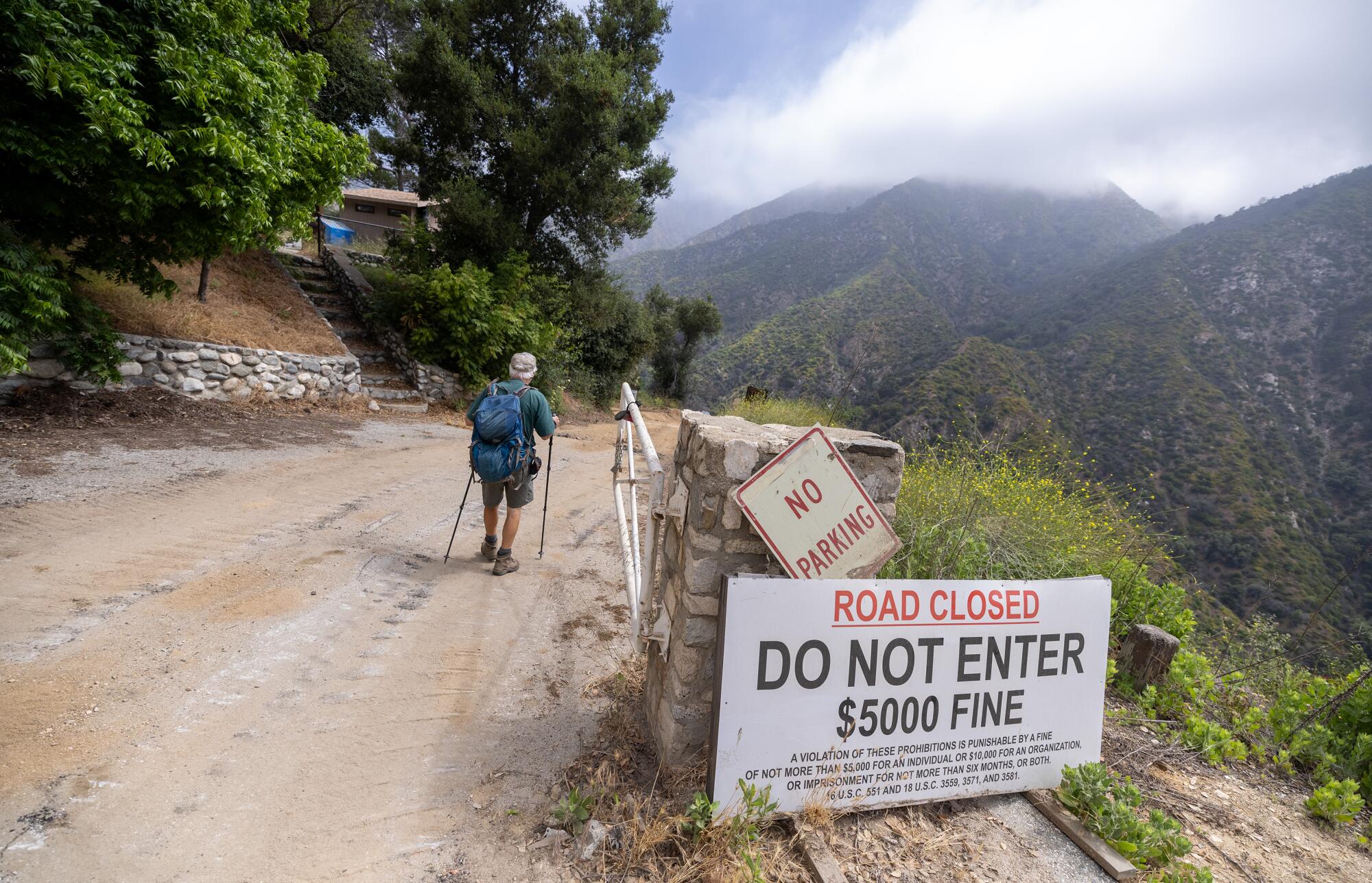Chris Kasten hikes past a "Road Closed" sign along the trail from Chantry Flat toward Sturtevant Falls.