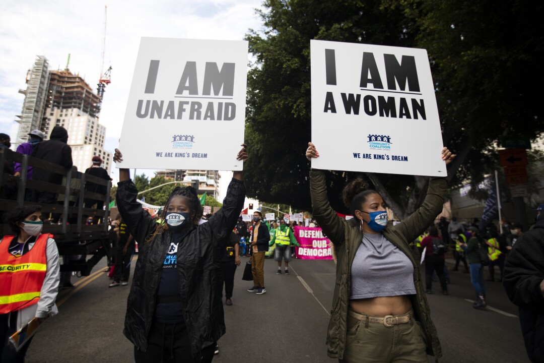 Protesters carry signs near L.A. City Hall.