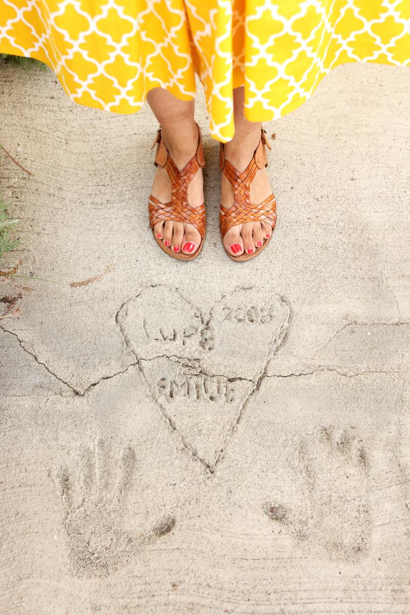 The names and handprints of the previous homeowners mark the walkway to Aurora Anaya's front door.