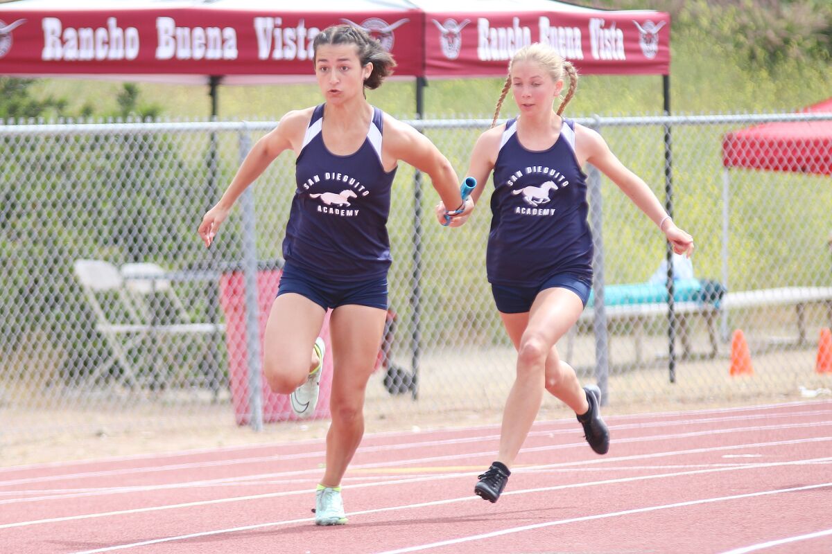 SDA's Mia Pullman hands the baton to Carly Renison in the 4x100 relay.