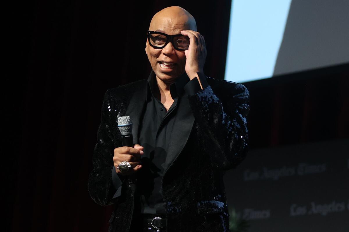 Rupaul laughs while speaking to a large audience to discuss his memoir.