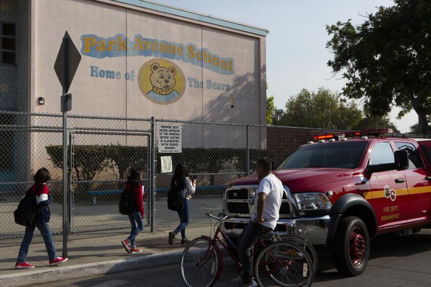 CUDAHY, CA-JANUARY 14, 2019: Kids walk past Park Avenue Elementary school after it was evacuated. Jet fuel was dumped on students playing on the playground, and students and school staff were treated for injuries, including skin irritation. (Gabriella Angotti-Jones/Los Angeles Times)