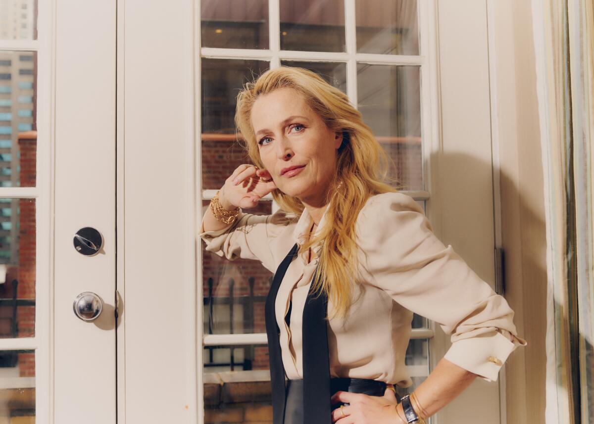 Gillian Anderson leans against French doors for a portrait shoot.