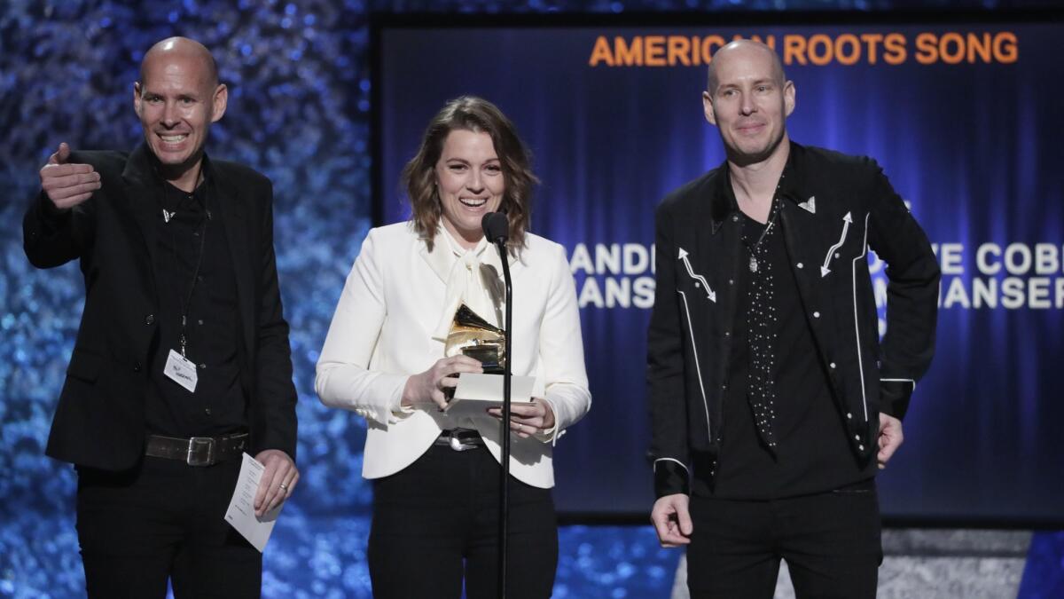 From left, Tim Hanseroth, Brandi Carlile and Phil Hanseroth, accept award for best American roots song for "The Joke" onstage at the Grammys pre-telecast ceremony.