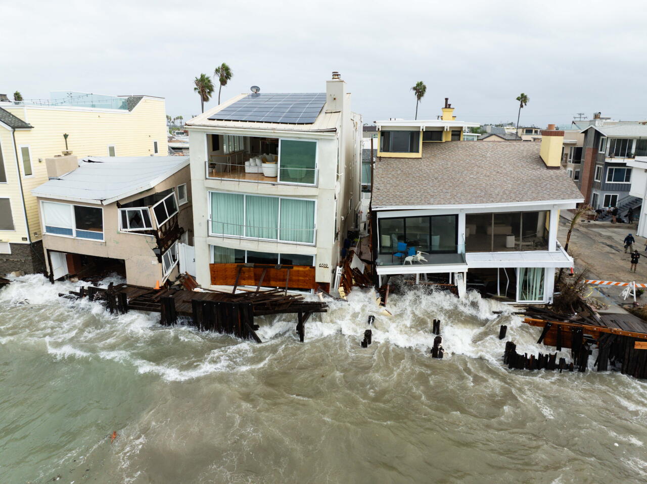 Waves crash against East Seaside Walk as homes collapse at the Long Beach Peninsula.