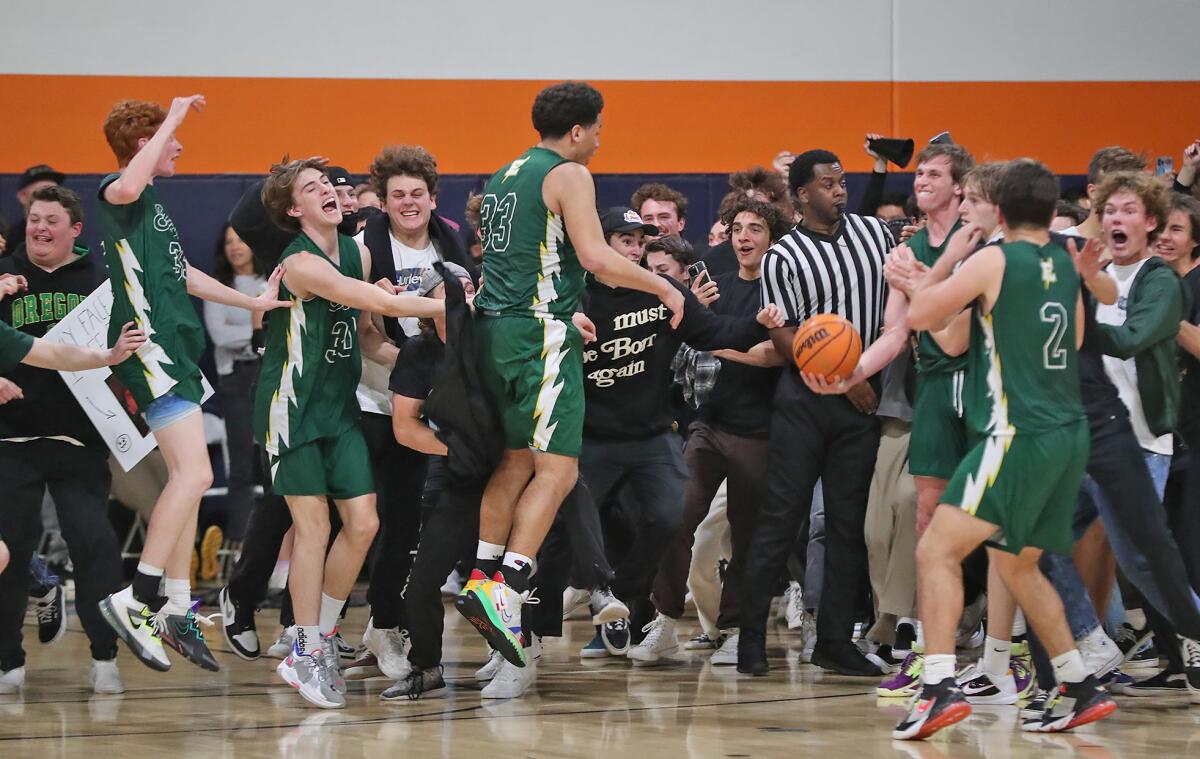 The Edison boys' basketball team and the student body celebrate a win against Pacifica Christian on Friday.