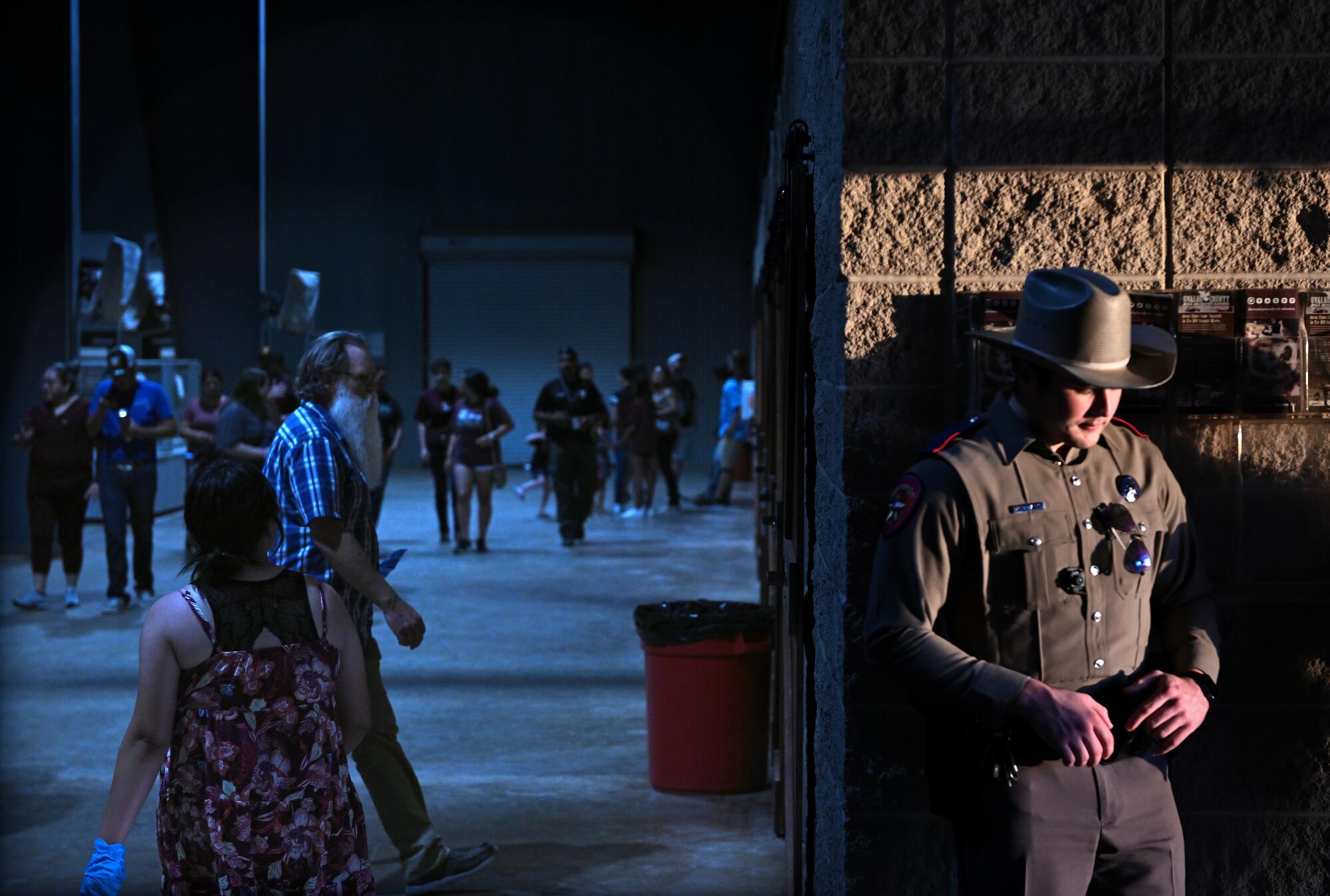 A police officer guards the door at the Uvalde County Fairplex during a vigil to honor the victims.