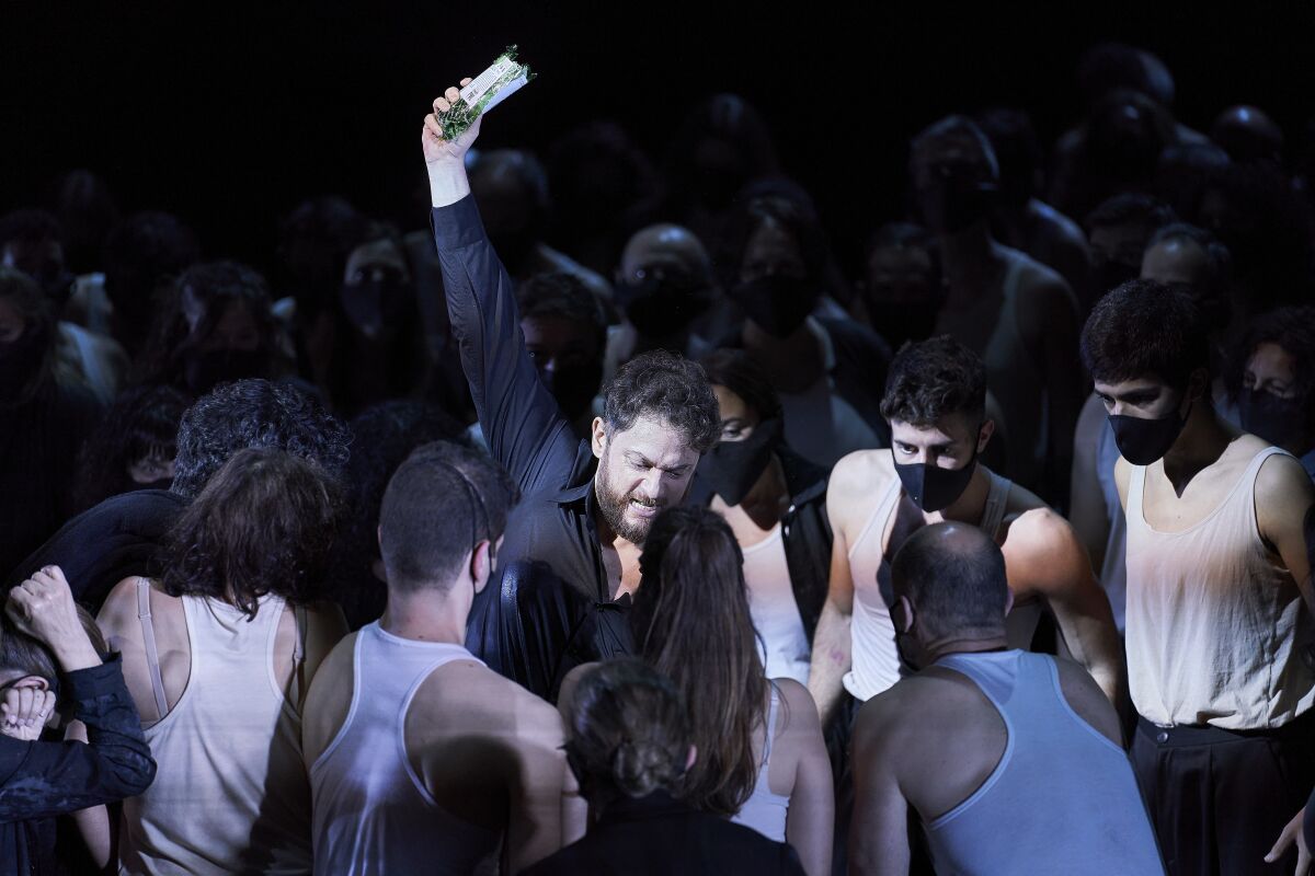 One of eight unmasked singers in "Otello" at Gran Teatre del Liceu in Barcelona, surrounded by masked chorus members