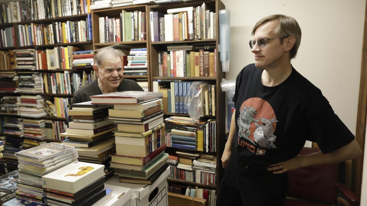 David Benesty, left, manager of Sam: Johnson's Bookshop shows store regular Phil Conrad collection of books.
