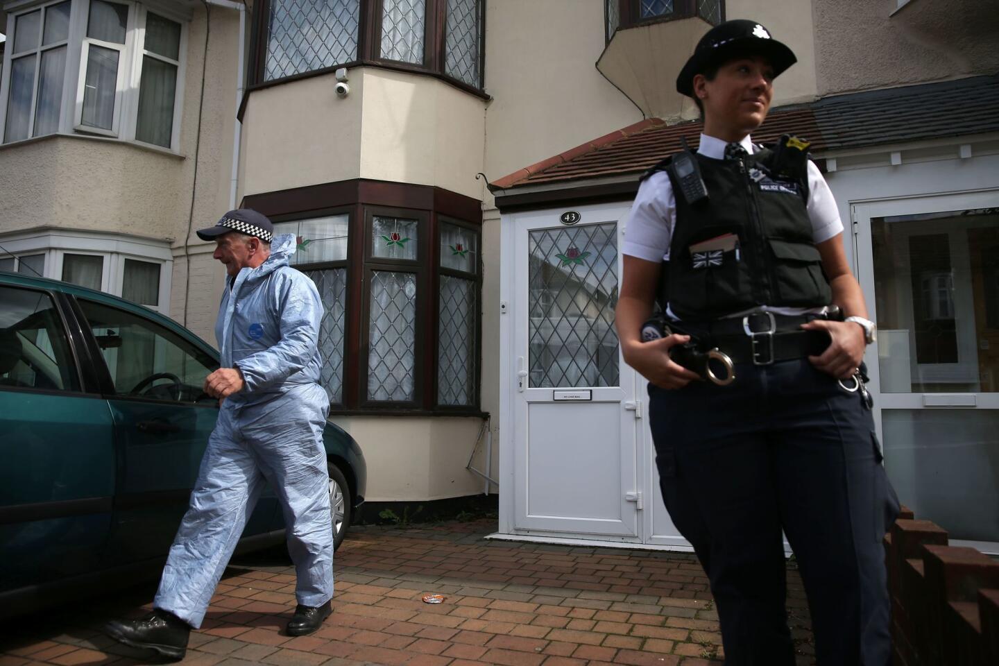 A police forensics officer walks out of a house during a operation in Ilford, east London, on Tuesday.