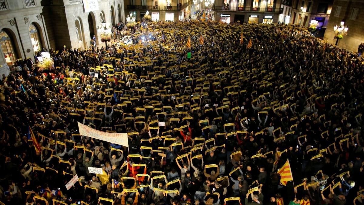 Demonstrators in Barcelona, Spain, holding banners reading "freedom for the political prisoners" in Catalan gather Friday, Nov. 3, 2017, outside the Palau Generalitat during a protest against the decision to jail ex-members of the Catalan government.