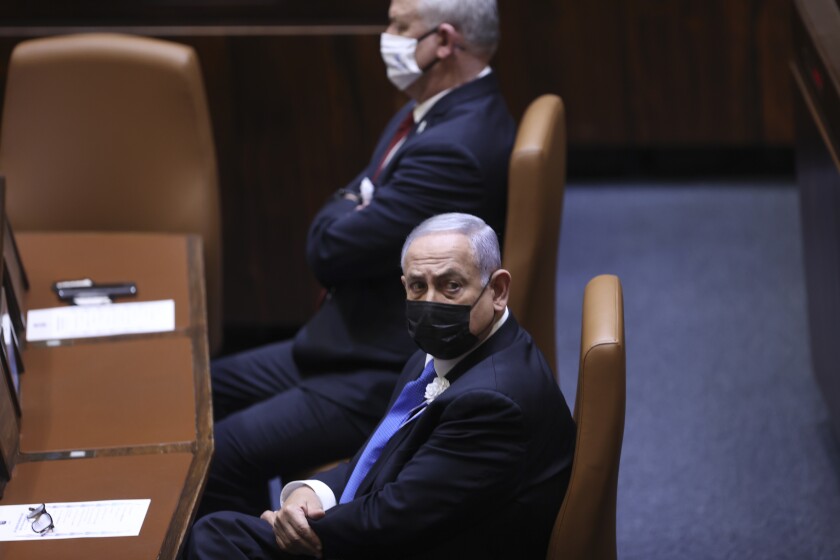 Israeli Prime Minister Benjamin Netanyahu, front, attends the swearing-in ceremony for Israel's 24th government, at the Knesset, or parliament, in Jerusalem, Tuesday, April 6, 2021. The ceremony took place shortly after the country's president asked Netanyahu to form a new majority coalition, a difficult task given the deep divisions in the fragmented parliament. (Alex Kolomoisky/Pool via AP)