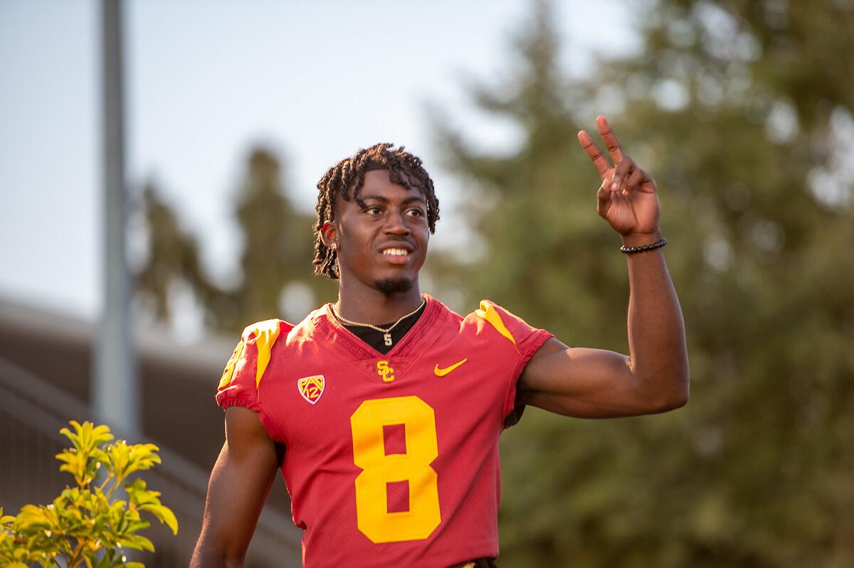 Zion Branch flashes the USC victory symbol while wearing his jersey.