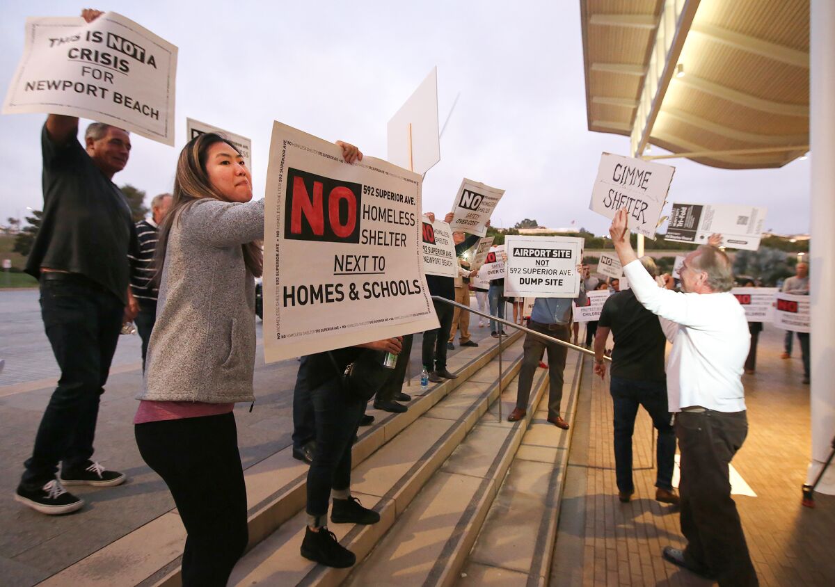 Protesters against a possible homeless shelter at the Newport Beach public works yard on Superior Avenue picket outside City Hall before Tuesday's City Council meeting.