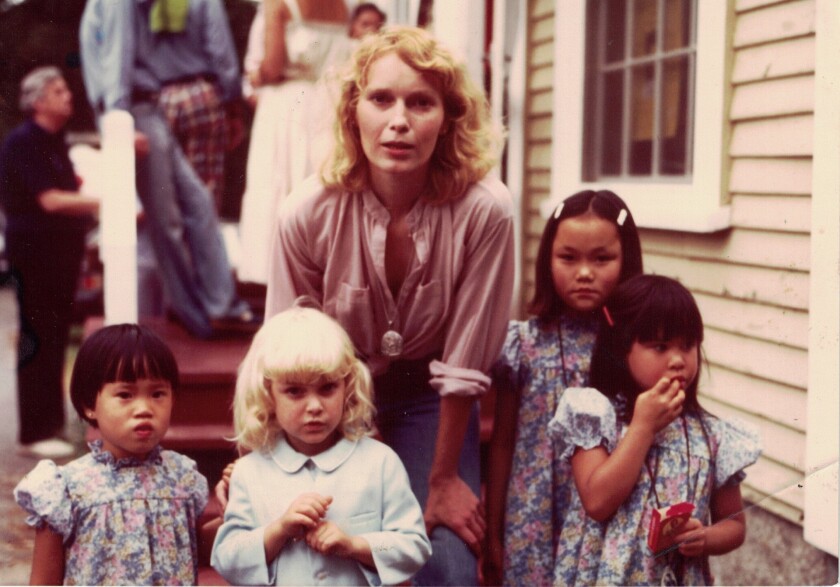 Mia Farrow stands with four of her young children in an old photo