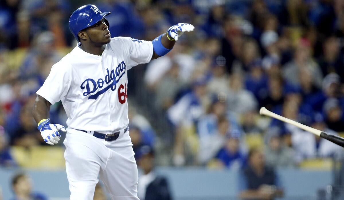 Dodgers right fielder Yasiel Puig flips his bat aside after connecting for a solo home run off the Giants' Madison Bumgarner in the sixth inning Friday night at Dodger Stadium.