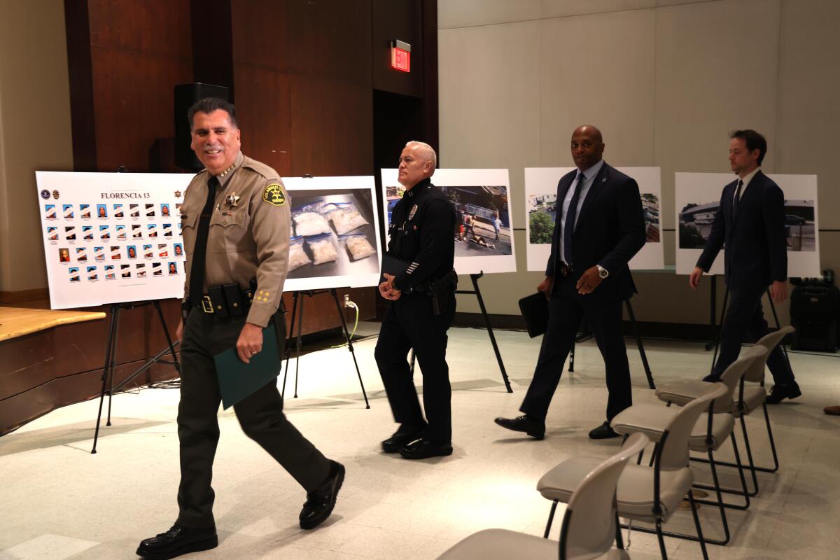 Los Angeles County Sheriff Robert Luna and other law enforcement leaders walk into a press conference.