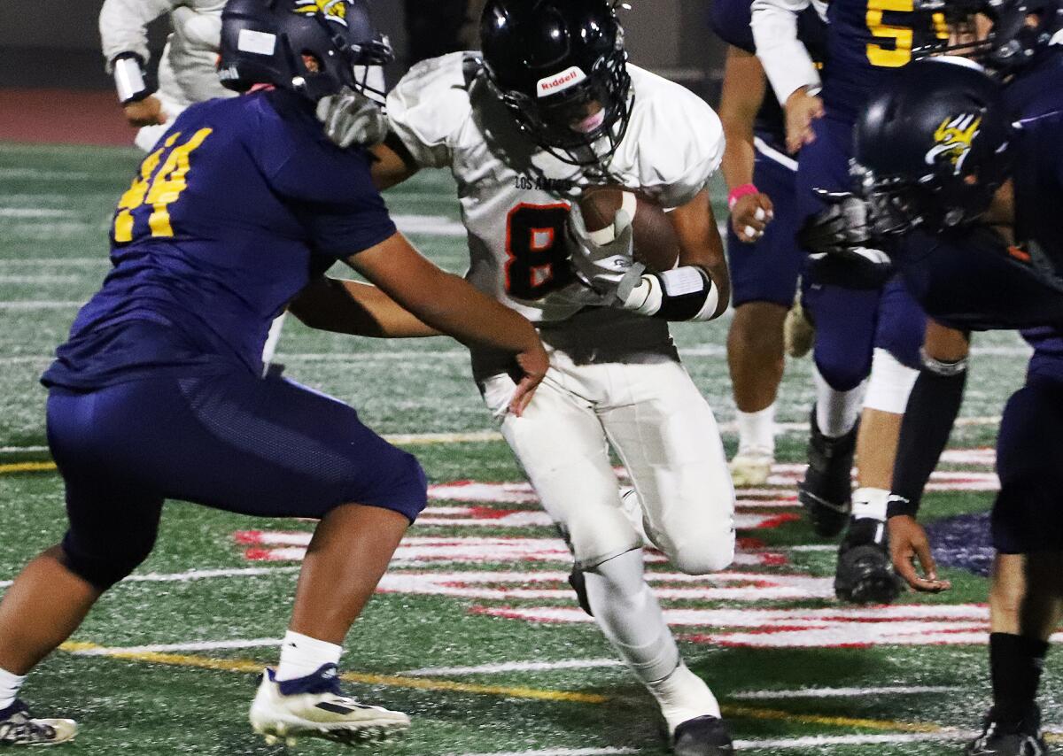 Los Amigos' Chris Flores (8) runs up the middle against La Quinta in a Garden Grove League game on Thursday.