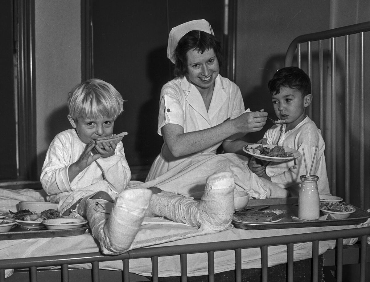 Nov. 28, 1935: Gordon Douglas, left, and Rupert Ortego are served Thanksgiving dinner by nurse Dorothy Barkell at General Hospital.