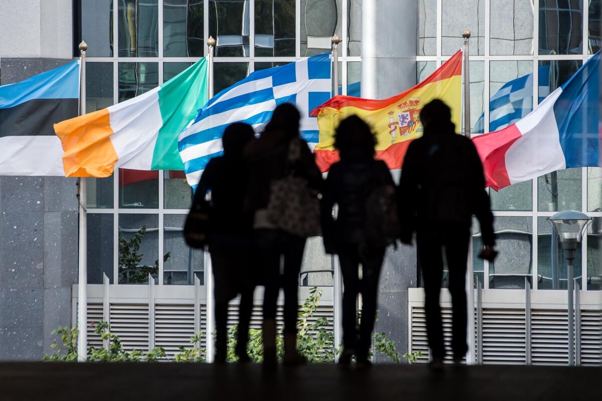 Pedestrians are silhouetted against the flags outside the European Parliament in Brussels. Despite eight countries' pending applications to join the 28-member European Union, no new additions are expected in the foreseeable future.