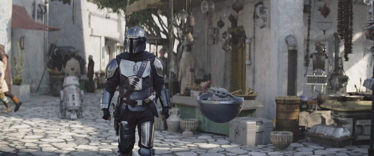 an alien toddler in a floating pram next to his helmeted warrior father
