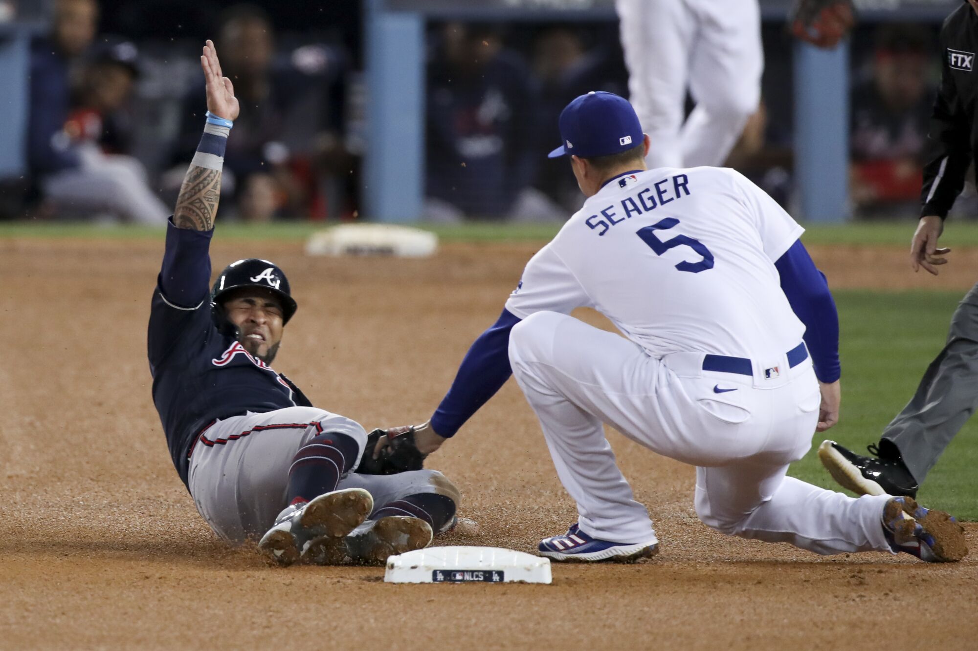  Dodgers shortstop Corey Seager, right tags out Braves' Eddie Rosario.