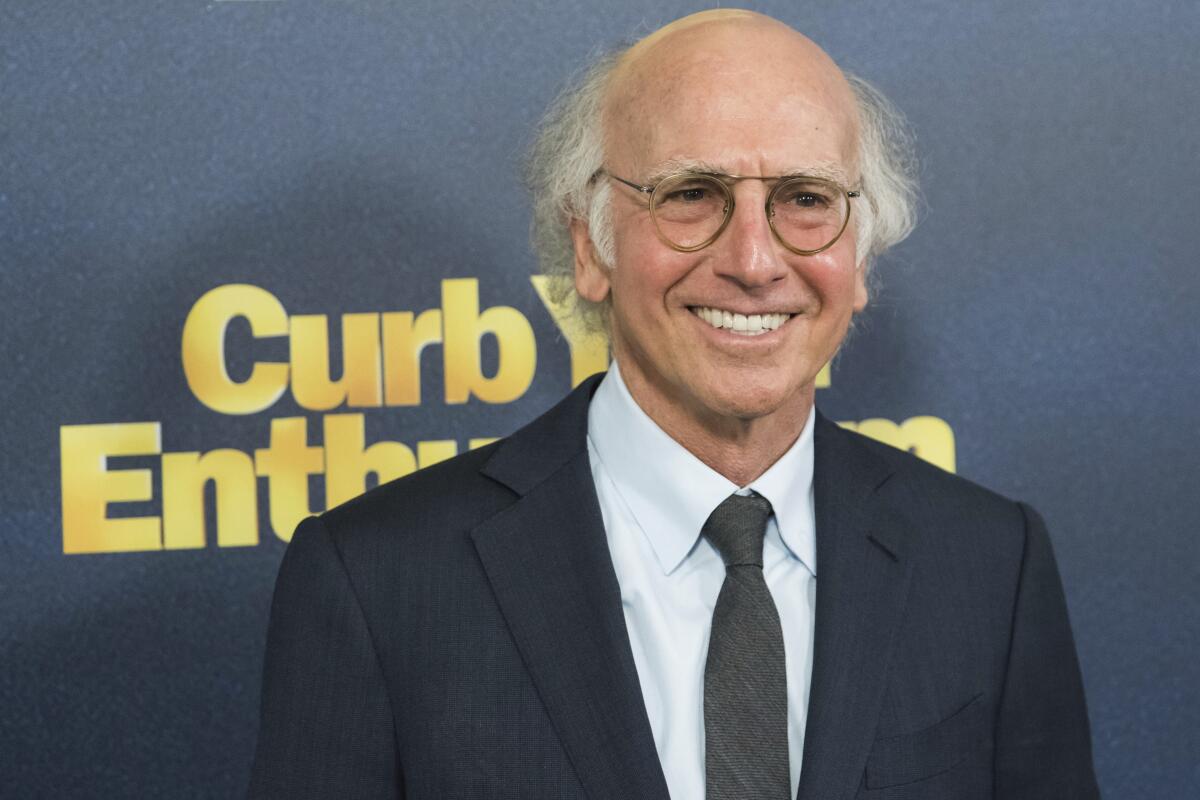 A balding man with glasses attends a TV premiere.