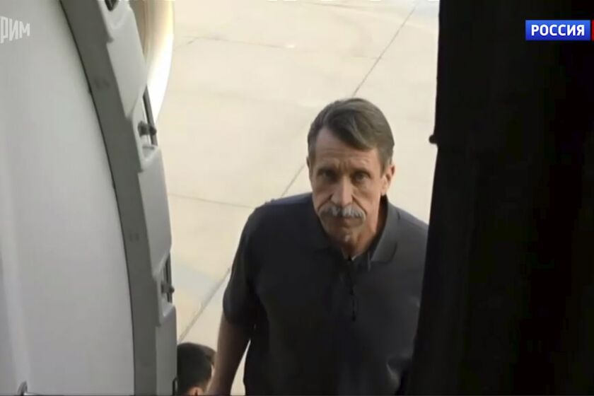 In this image taken from video provided by the RU-24 Russian Television on Friday, Dec. 9, 2022, Russian citizen Viktor Bout, right, who was exchanged for U.S. basketball player Brittney Griner, boards a Russian plane after a swap, in the airport of Abu Dhabi, United Arab Emirates. Russian arms dealer Bout, who was released from U.S. prison in exchange for WNBA star Griner, is widely labeled abroad as the "Merchant of Death" who fueled some of the world's worst conflicts but seen at home as a swashbuckling businessman unjustly imprisoned after an overly aggressive U.S. sting operation. (RU-24 Russian Television via AP)
