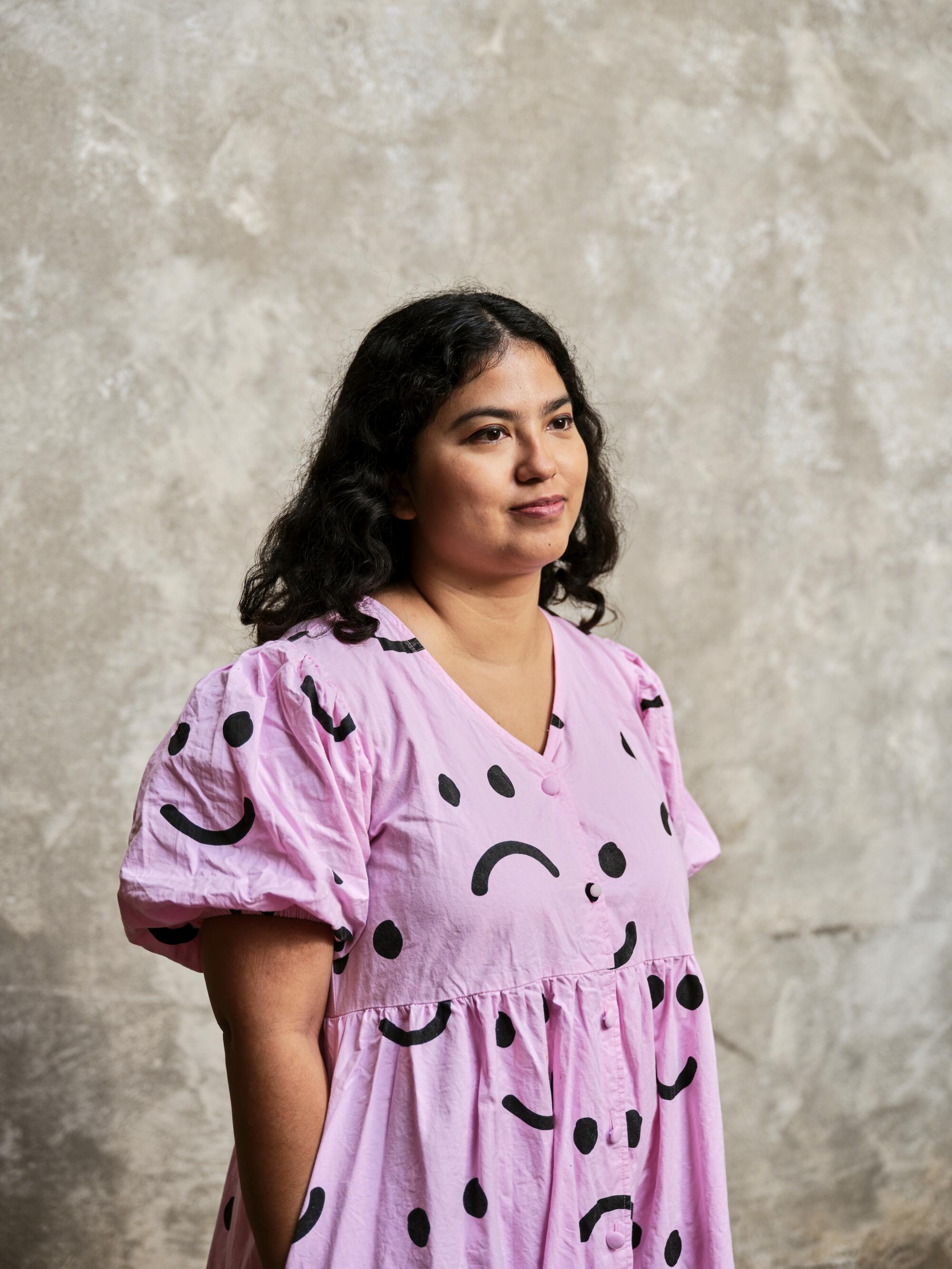 Eva Recinos, an arts and culture journalist and creative nonfiction writer, stands for a portrait at her home.