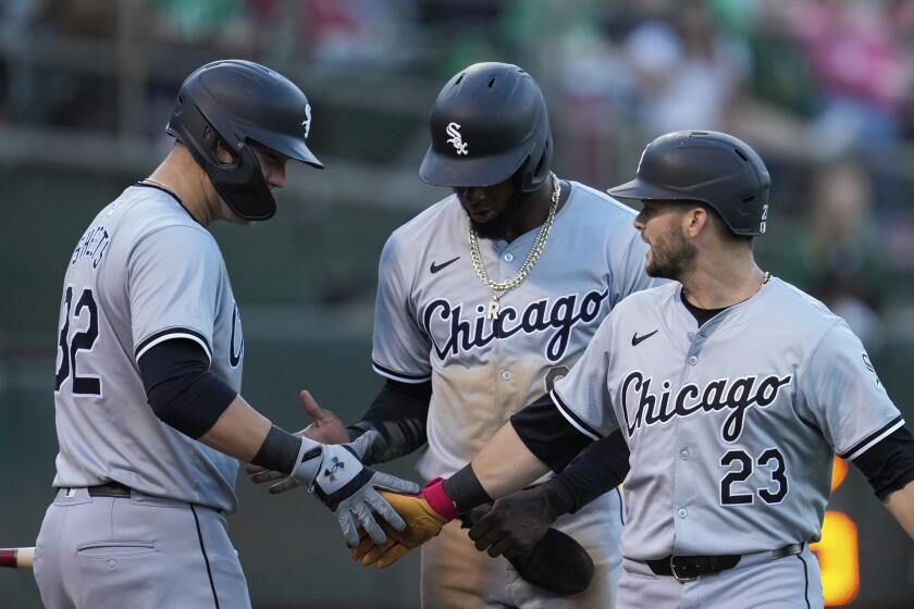 Chicago White Sox's Andrew Benintendi, right, celebrates with Gavin Sheets, left, after hitting a two-run home run 