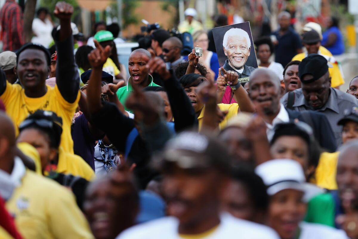 South Africans sing and dance to celebrate the life of Nelson Mandela outside his former home in Soweto on Saturday.