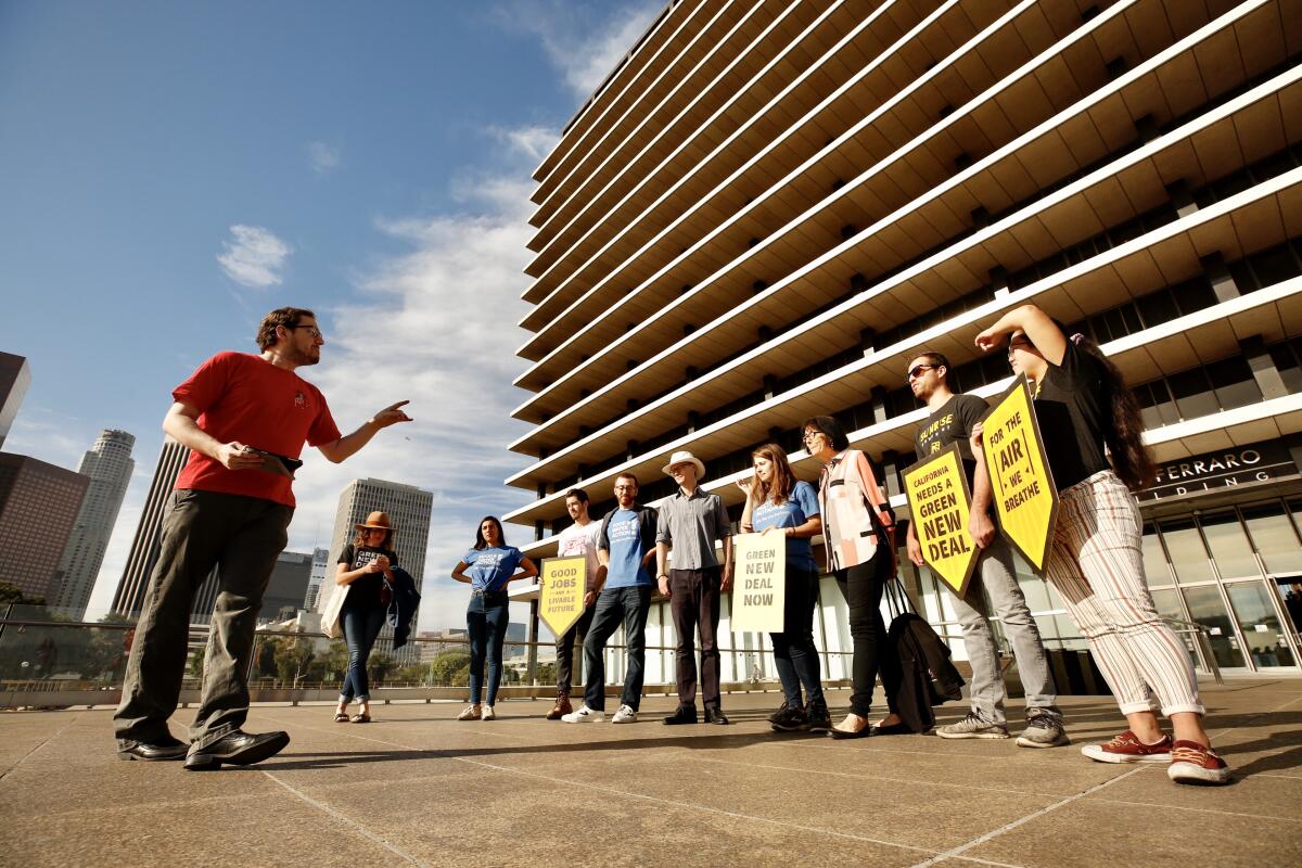 Tom Pike, left, a member of Los Feliz Neighborhood Council's environmental affairs committee, leads a rally outside the Los Angeles Department of Water and Power's headquarters on Nov. 19, 2019, protesting LADWP's plan to build a gas-fired power plant in Utah.