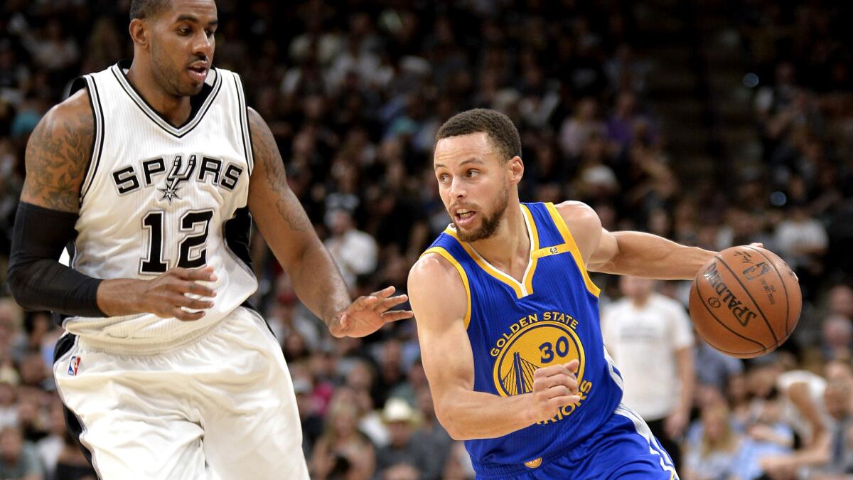 Warriors guard Stephen Curry (30) drives around Spurs forward LaMarcus Aldridge during a regular-season game in March.