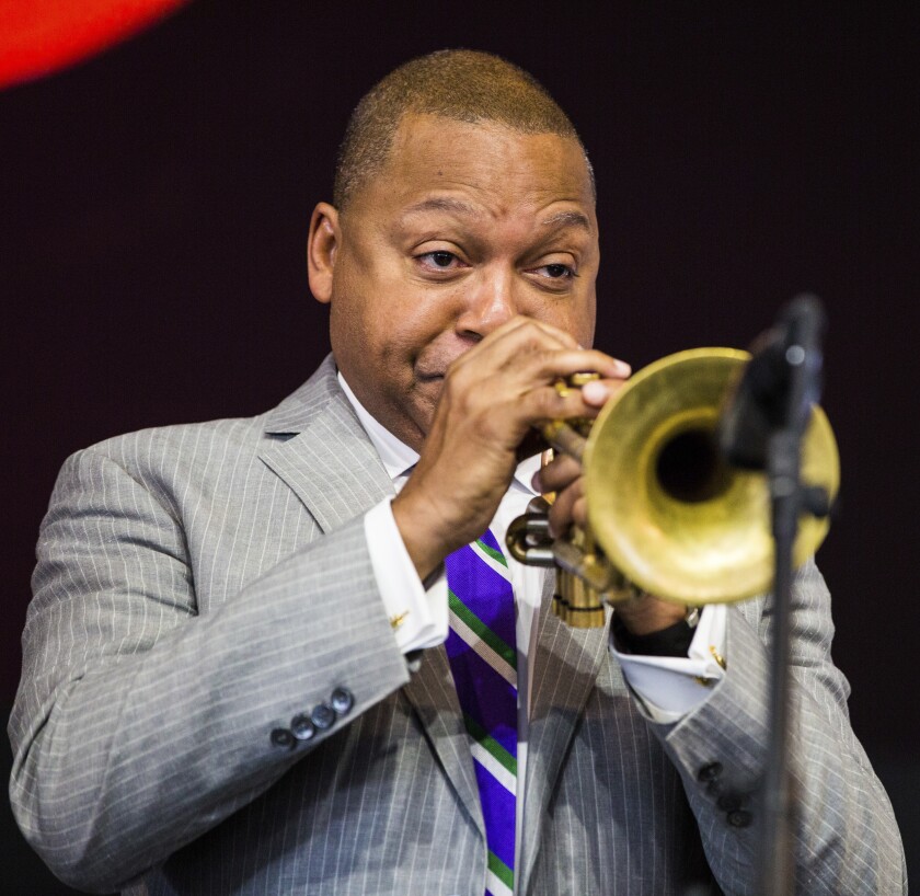 Wynton Marsalis is seen in close-up on stage playing his trumpet.