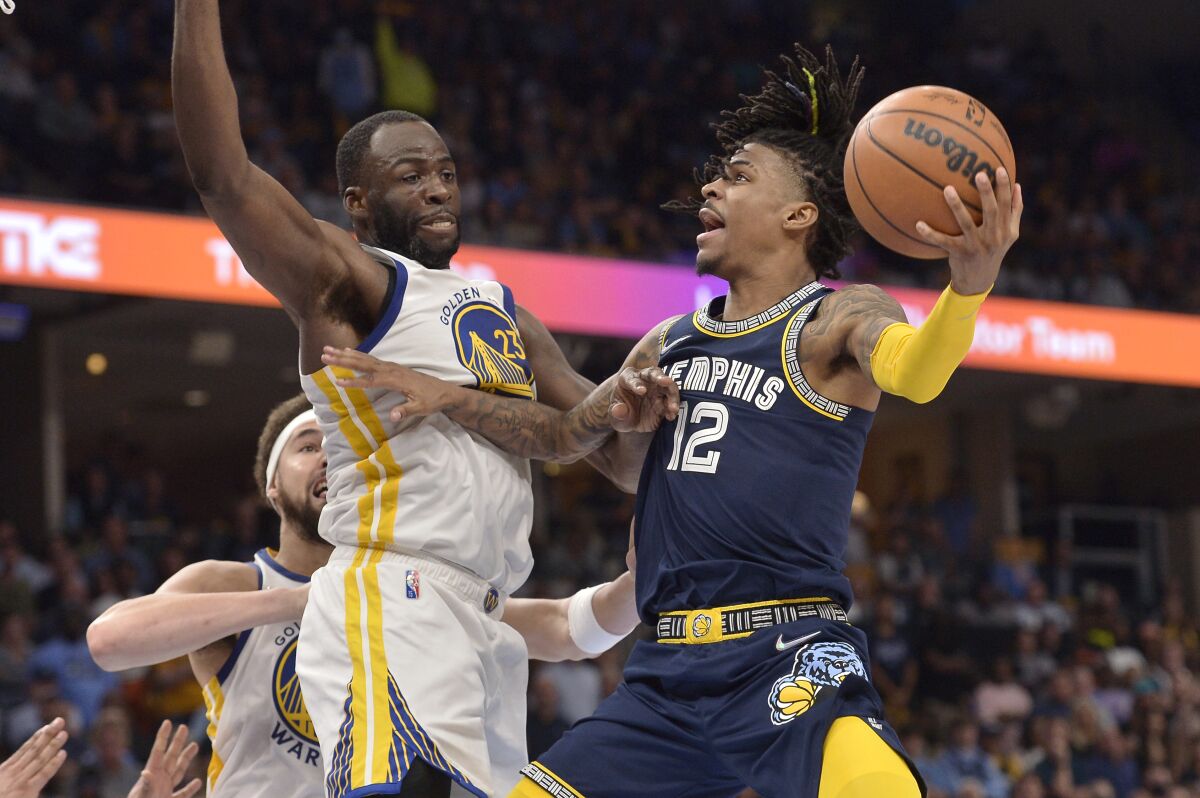 Memphis Grizzlies guard Ja Morant (12) shoots against Golden State Warriors forward Draymond Green (23) during the second half of Game 2 of a second-round NBA basketball playoff series Tuesday, May 3, 2022, in Memphis, Tenn. (AP Photo/Brandon Dill)