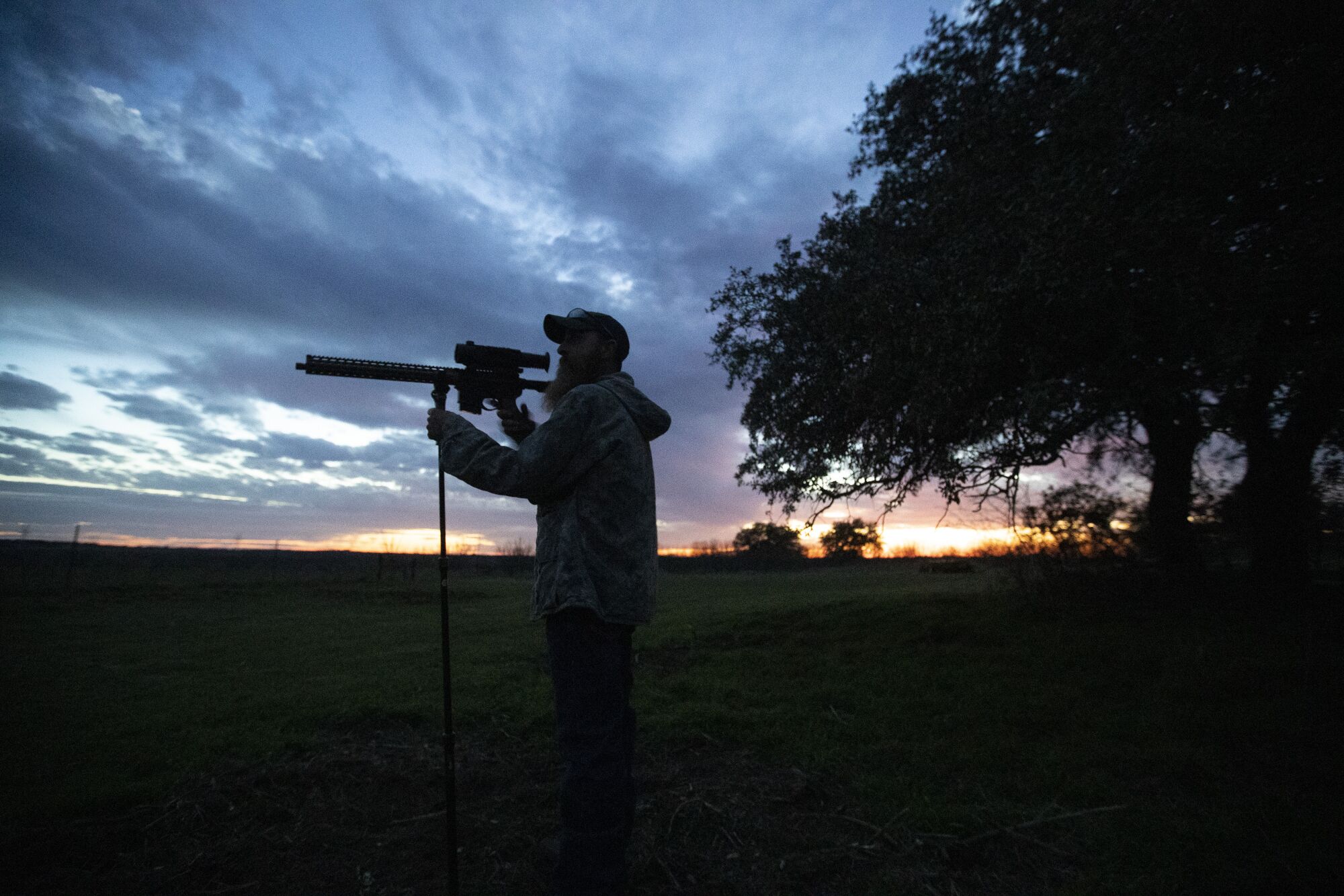 Fred Jones peers through the infrared scope on his rifle in rural Throckmorton County, Texas.