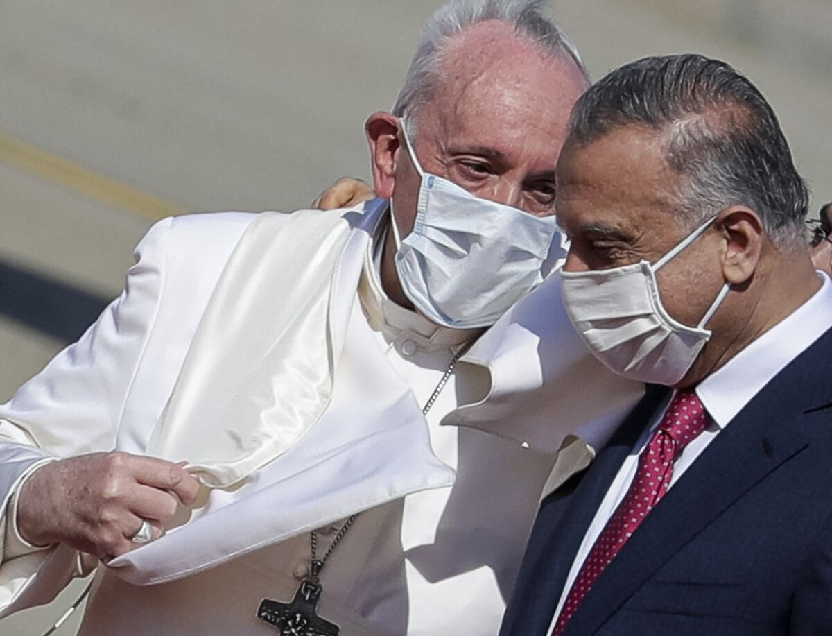 FILE - Pope Francis is greeted by Iraqi Prime Minister Mustafa al-Kadhimi as he arrives at Baghdad's international airport, Iraq, on March 5, 2021. Pope Francis is condemning the assassination attempt against Iraq’s prime minister as a “vile act of terrorism” and says he is praying for peace in the country. The Vatican secretary of state, Cardinal Pietro Parolin, sent a telegram Tuesday to Prime Minister Mustafa al-Kadhimi expressing Francis’ solidarity and prayers to al-Kadhimi’s family and those injured in the drone attack on the prime minister’s residence. (AP Photo/Andrew Medichini)