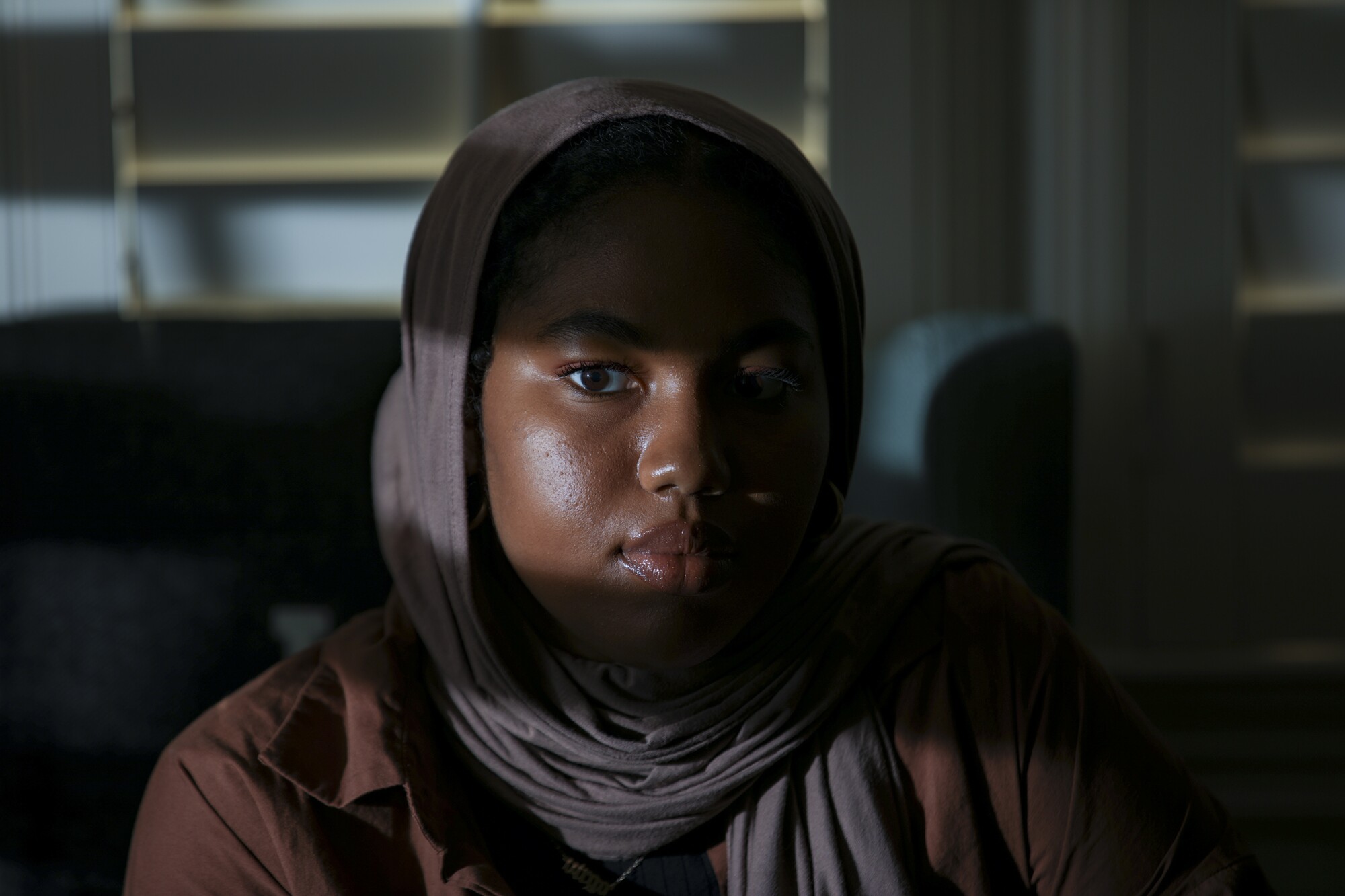 A woman wearing a head covering poses for a portrait.