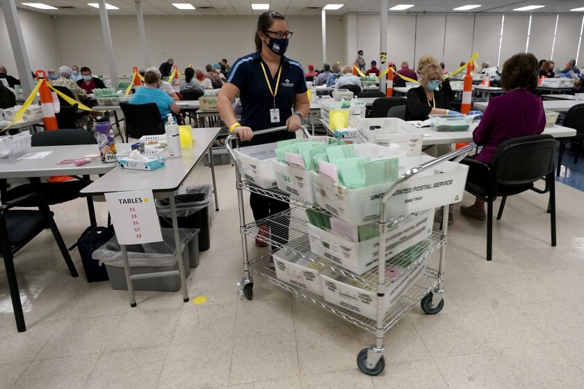 FILE - This Oct. 21, 2020, file photo shows election workers sorting ballots at the Maricopa County Recorder's Office in Phoenix. Despite massive turnout for early voting, elections are going pretty smoothly in the battleground state of Arizona. (AP Photo/Matt York, File)