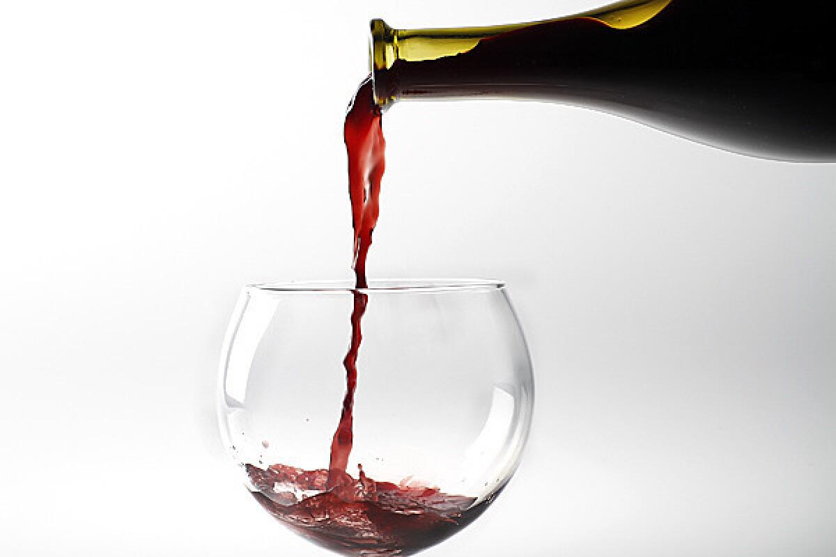 Red wine is poured from a bottle.