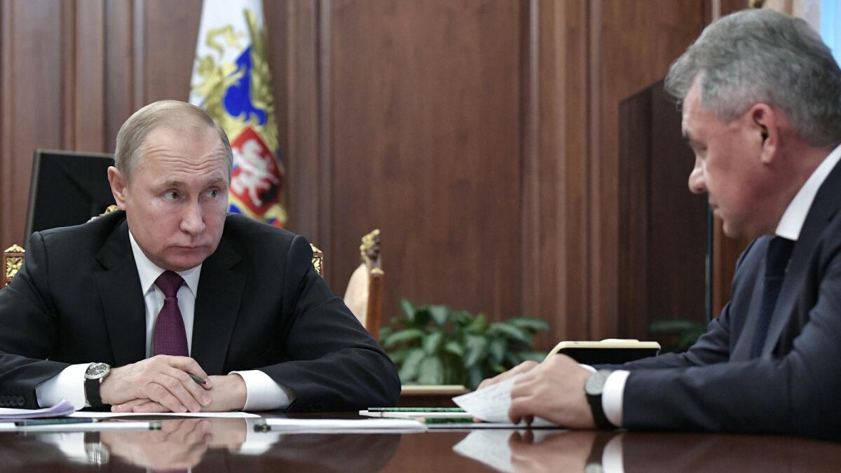 Russian President Vladimir Putin, left, speaks to Defense Minister Sergei Shoigu in the Kremlin on Saturday.