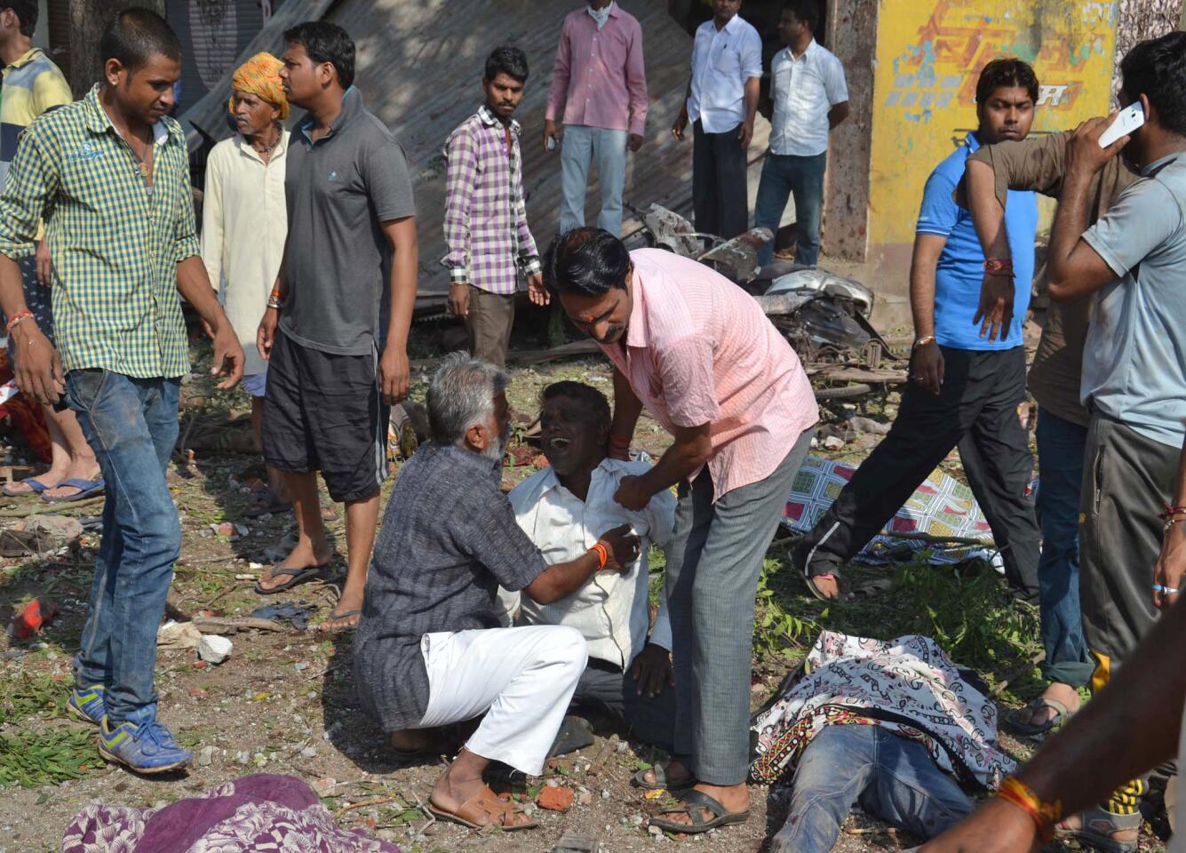 An injured man, whose relatives were killed, cries at the site of an explosion, with bodies of the dead lying around him, in Petlawad, in the central Indian state of Madhya Pradesh, Saturday, Sept. 12, 2015. Dozens of people were killed at a restaurant in central India on Saturday when a cooking gas cylinder exploded and triggered a second blast of mine detonators stored illegally nearby, police said. (AP Photo/Manoj Jani)