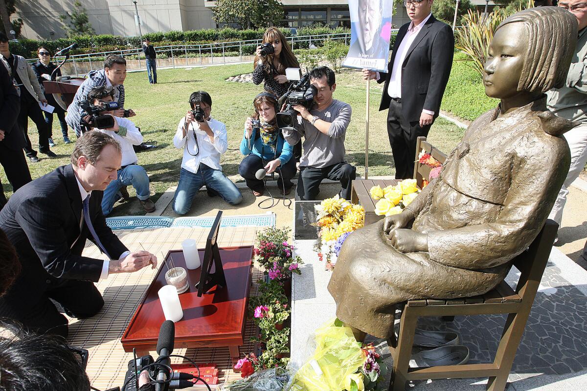 Congressman Adam Schiff lights incense and kneels before the Glendale Comfort Woman statue on Tuesday, April 22, 2014, in honor of 87-year-old former comfort woman Li Xiumei who died recently.