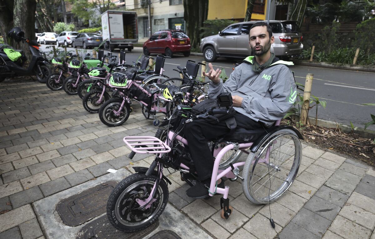 Martin Londoño, owner of MATT, an electric wheelchair tour company talks during an interview in Medellin, Colombia, Wednesday, Nov. 18, 2020. Londoño, 31, started to work on the hand-cycles four years ago in a bid to improve his own mobility. He lost the use of his legs after breaking his spinal chord in a traffic accident at age 18. (AP Photo/Fernando Vergara)