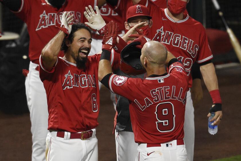 Los Angeles Angels' Tommy La Stella, right, celebrates with Anthony Rendon at home plate.