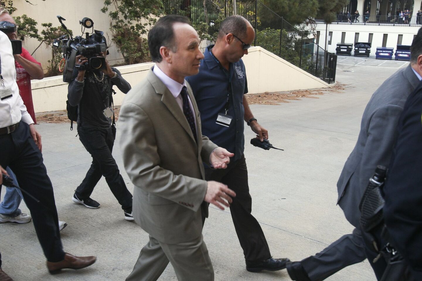 San Diego State president Elliot Hirshman, front center, is escorted away.