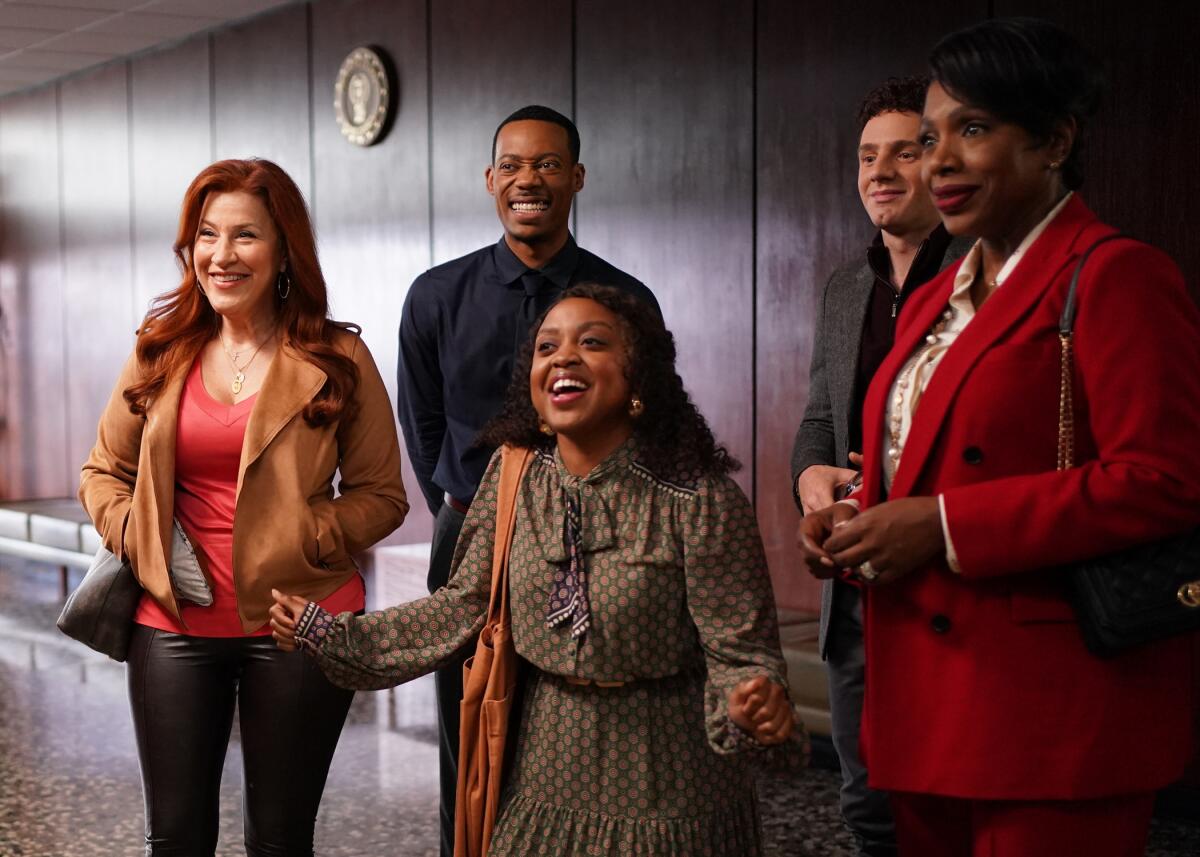 Actors playing a group of smiling teachers at a big-city elementary school.